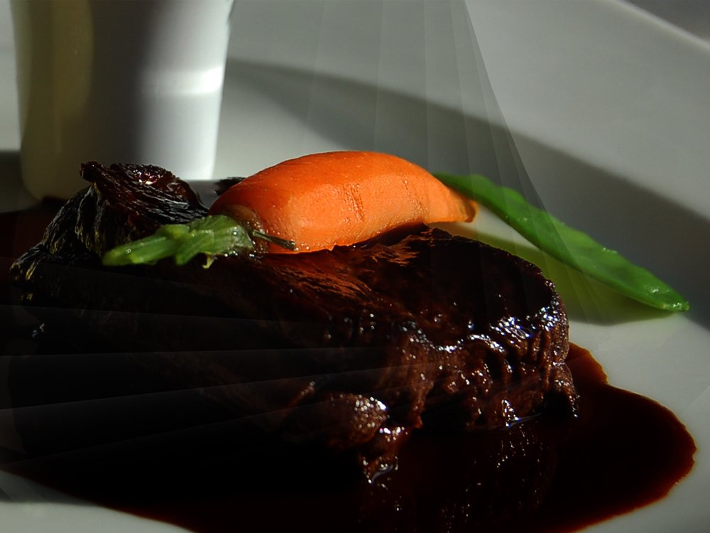 Une assiette de viande, jus réduit, carotte et asperge