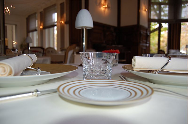 Table dressée, assiette de présentation et verre de cristal