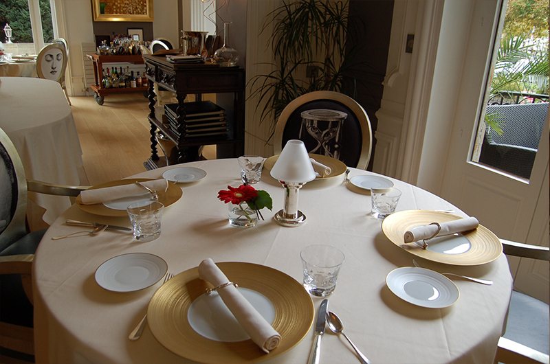 Table ronde dressée pour quatre, assiettes dorées