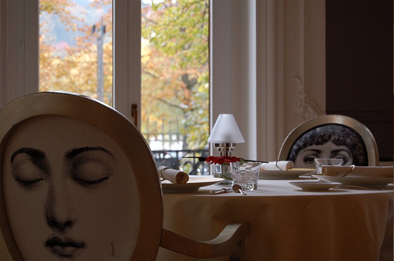 Dossier de chaise orné d'un visage de femme, devant une fenêtre